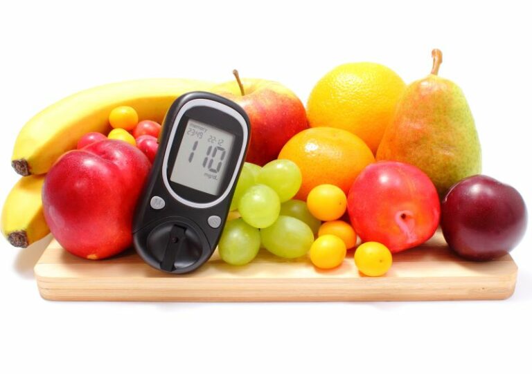 pile of fruit with diabetic blood glucometer in front