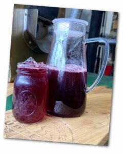 Pitcher and glass of Summer berry iced tea and ice