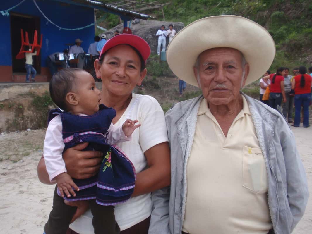 Cafe femenino coffee growers, older man and a woman holding a baby