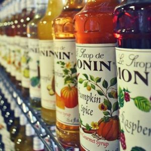 Monin syrup bottles on wire shelf