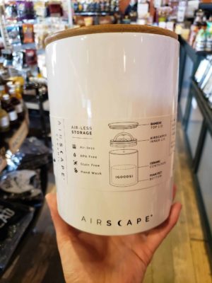 Hand holding a 7 inch tall Airscape ceramic Canister in Snowflake White.