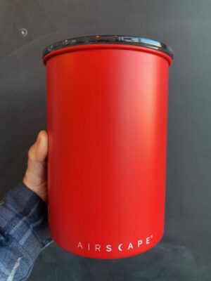 Airscape 7 inch Matte Red Metal Canister being held by a hand