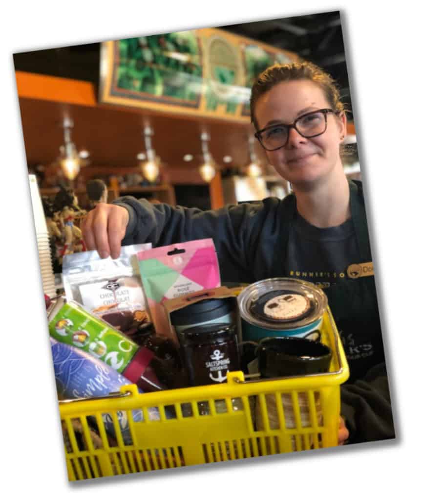 a personal shopper standing with a filled basket of gifts to go