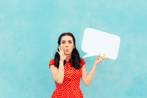 blue background with a woman in red polka dot dress holding an empty speech bubble