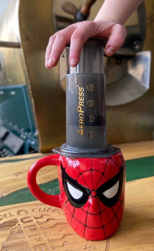 Aeropress coffee being pressed into a Spiderman mug