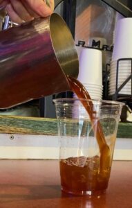 pouring an aerocano into a glass