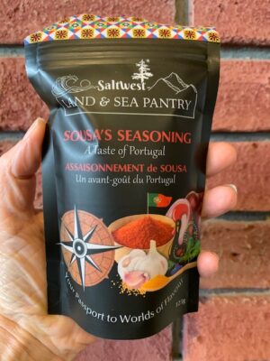 a bag of Saltwest Sousa's Seasoning held by a hand in front of a brick wall