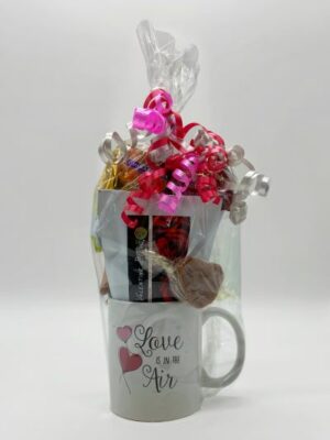 Valentines basket coffee mug with treats, wrapped in cellophane and red ribbons