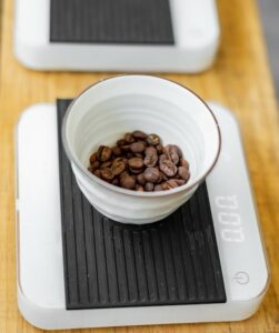 small weigh scale with a bowl of roasted coffee beans