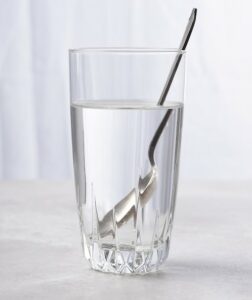 large glass of water with a spoon