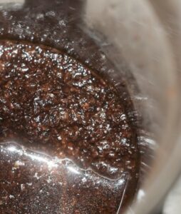 A closeup of wet coffee grounds in an Aeropress brewer