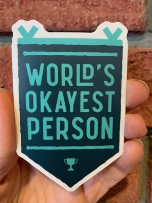 sticker worlds okayest person on a green banner