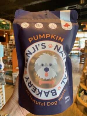 A large purple bag of Benji's Pumpkin Dog Treats being held by a hand at Cupper's Coffee & Tea.