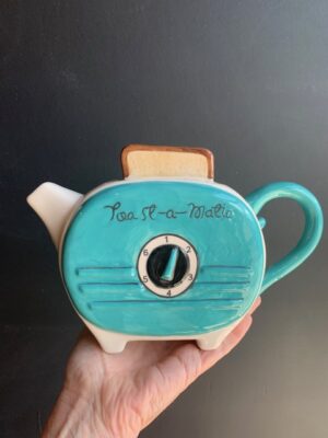 Green Retro Toaster Teapot made by Blue Sky being held by a hand