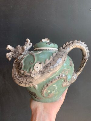 Green Dragon Teapot made by Blue Sky being held by a hand