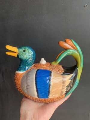 Mallard Duck Teapot made by Blue Sky being held by a hand