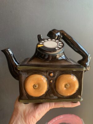 Retro Telephone Teapot made by Blue Sky being held by a hand