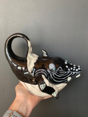 Whale Teapot made by Blue Sky being held by a hand