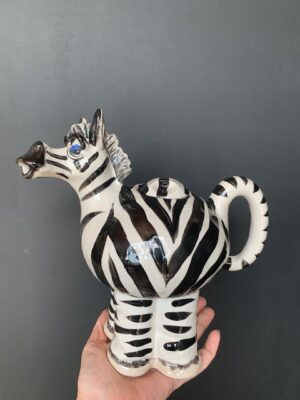 Zebra Teapot made by Blue Sky being held by a hand