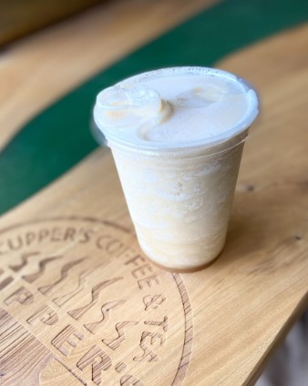 Cold cup and sippy lid with frappe on the cupper's counter