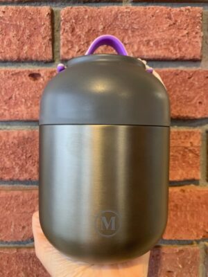 Thermal Food Jar Gunmetal, 700 mL is dark brushed metal and a plastic bowl lid. The lid has a pink & purple handle.