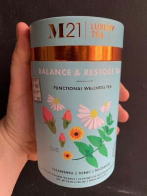 M21 Balance & Restore tea being held by a hand