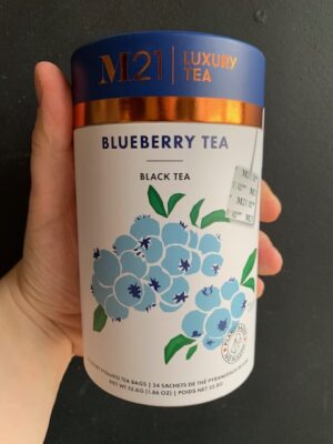 M21 Blueberry Tea being held by a hand