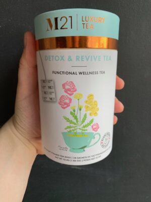 M21 Detox & Revive Tea being held by a hand