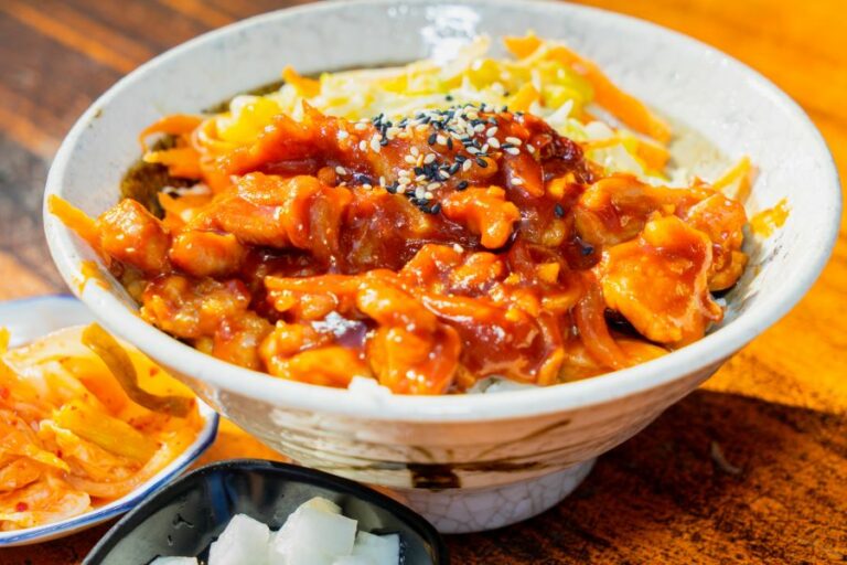 A large white bowl of slow cooker chicken with a honey truffle glaze