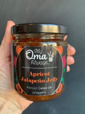 Apricot Jalapeno Jelly made by My Oma Always, being held by a hand