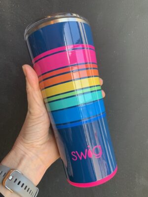 Swig Electric Slide 22 ounce tumbler being held by a hand