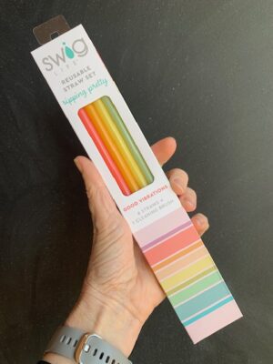 Swig Good Vibrations reusable straw set with brush being held by a hand