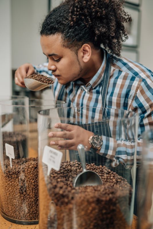 A man smelling a scoop of coffee for freshness