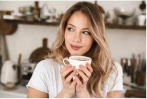 Blonde woman in White with a coffee mug