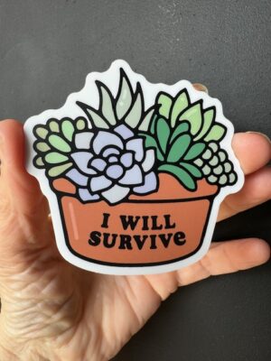 Hand holding a sticker with cacti in a terracotta bowl with "I will survive".