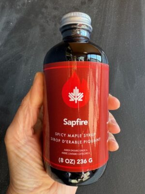 a hand holding a bottle of Dript Sapfire Maple Syrup