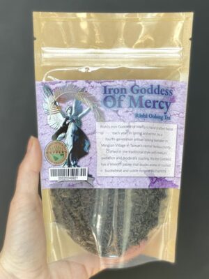A hand holding a bag of loose Rishi Iron Goddess of Mercy Oolong Tea