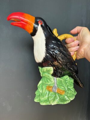 a hand holding a Blue Sky Clayworks Toucan Teapot