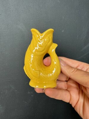 Mini Gluggle Jug in Yellow being held by a hand