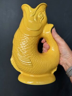 Extra large Gluggle Jug in Yellow being held by a hand