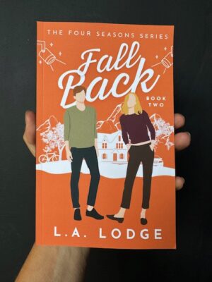 A hand holding the book 'Fall Back" by L. A. Lodge