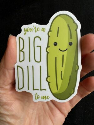 Hand holding a sticker with a dill pickle and text "You're a big dill to me"