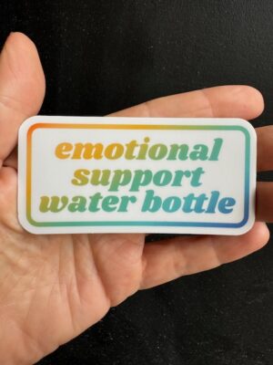 Hand holding a sticker with ombre text "emotional support water bottle"