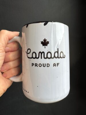 Prairie Chick Mug in white with small maple leaf and text "Canada Proud AF"
