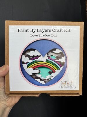 Shadow Box painting kit called Love featuring heart cutout with clouds and a rainbow showing through.