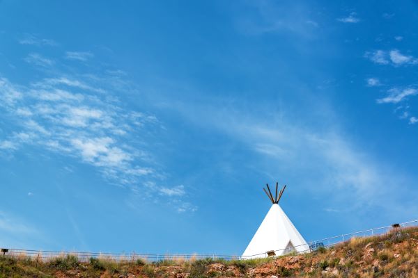 an Indian Teepee on the horizon of the Head-Smashed-In-Buffalo-Jump