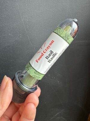 Basil food crayon in front of a black background