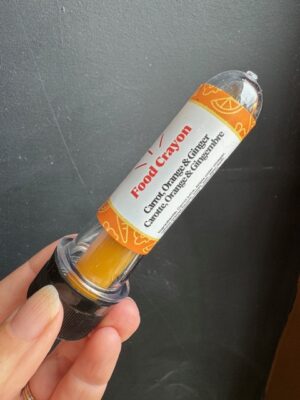 Carrot, Orange & Ginger food crayon in front of a black background