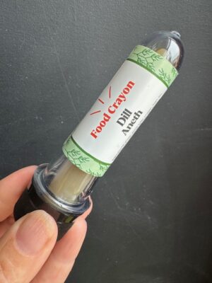 Dill food crayon in front of a black background