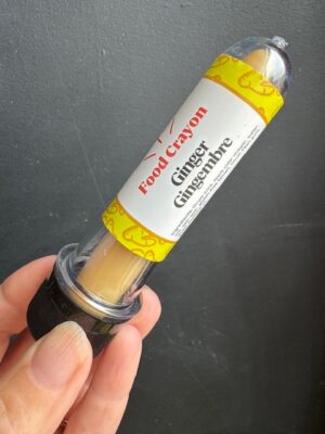 Ginger food crayon in front of a black background